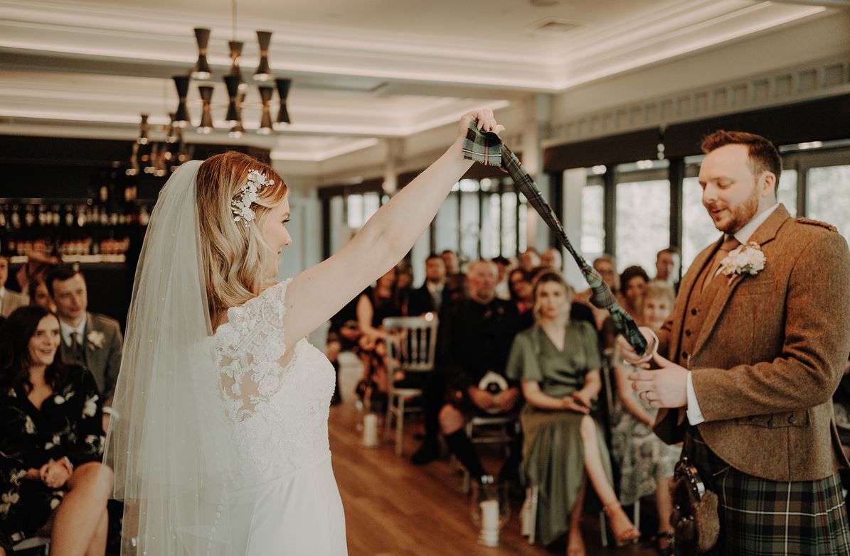 a photo of a couple tying the knot in a hand-fasting ritual with mary gibson the celebrant angel aberdeen wedding aberdeen